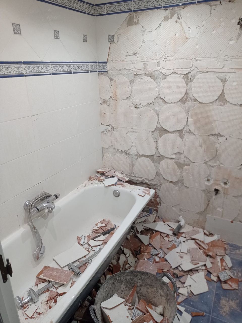 Bañera antigua en demolición, con el azulejo retirado