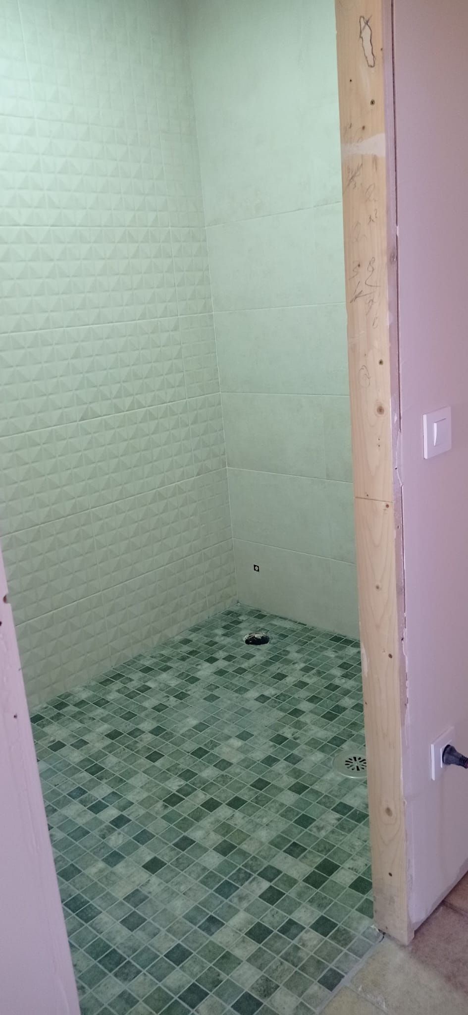 Ducha de obra a ras de suelo con mosaico verde antideslizante y azulejo blanco en relieve