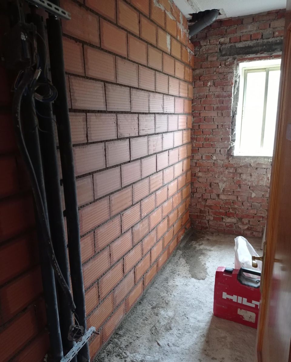 El baño antes de la reforma, con el tabique de ladrillo levantado y la ventana sin rematar