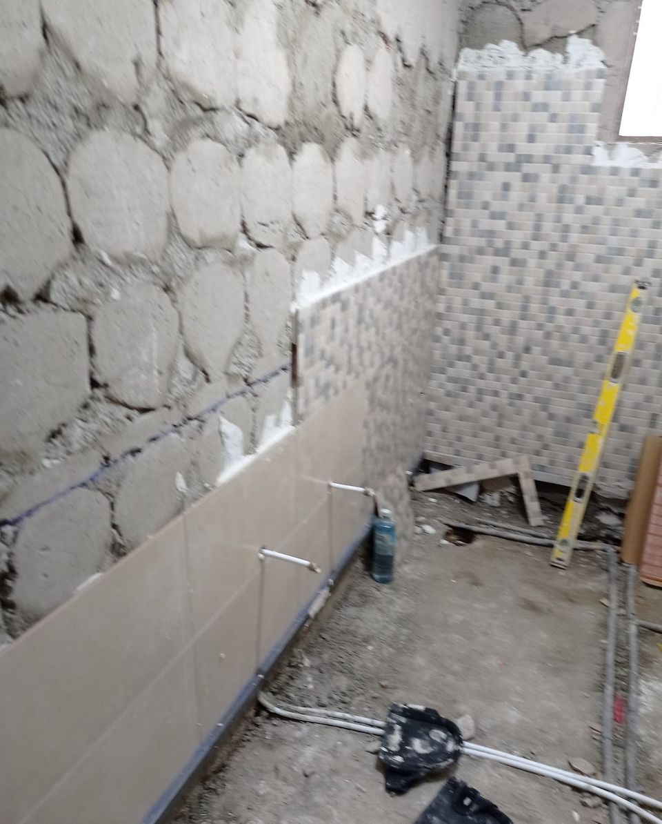 El mismo baño durante la obra, con el alicatado y el mosaico a medio colocar