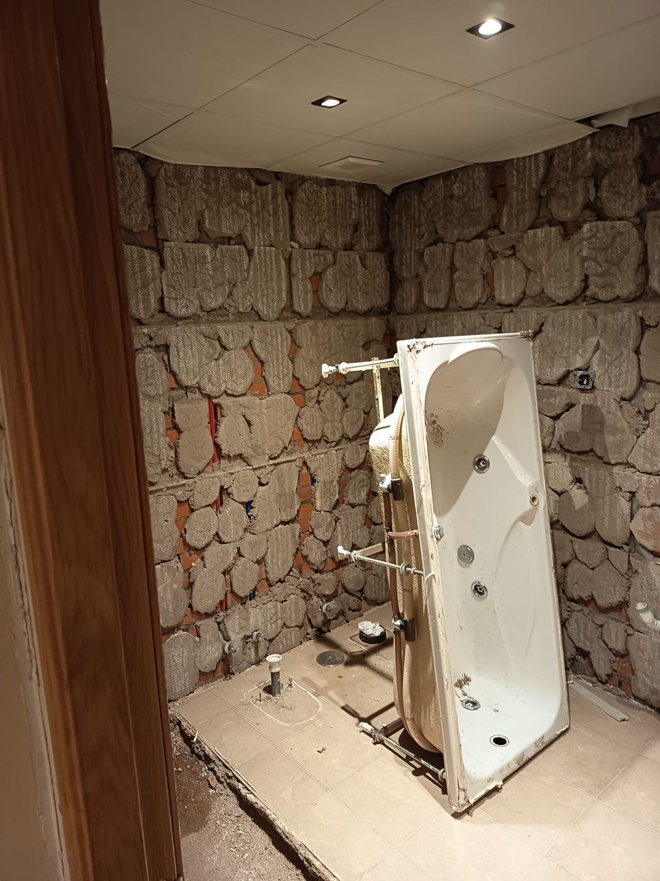 Baño en demolición con la antigua cabina de hidromasaje retirada