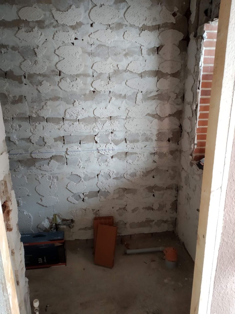 Baño en obra con paredes de ladrillo visto