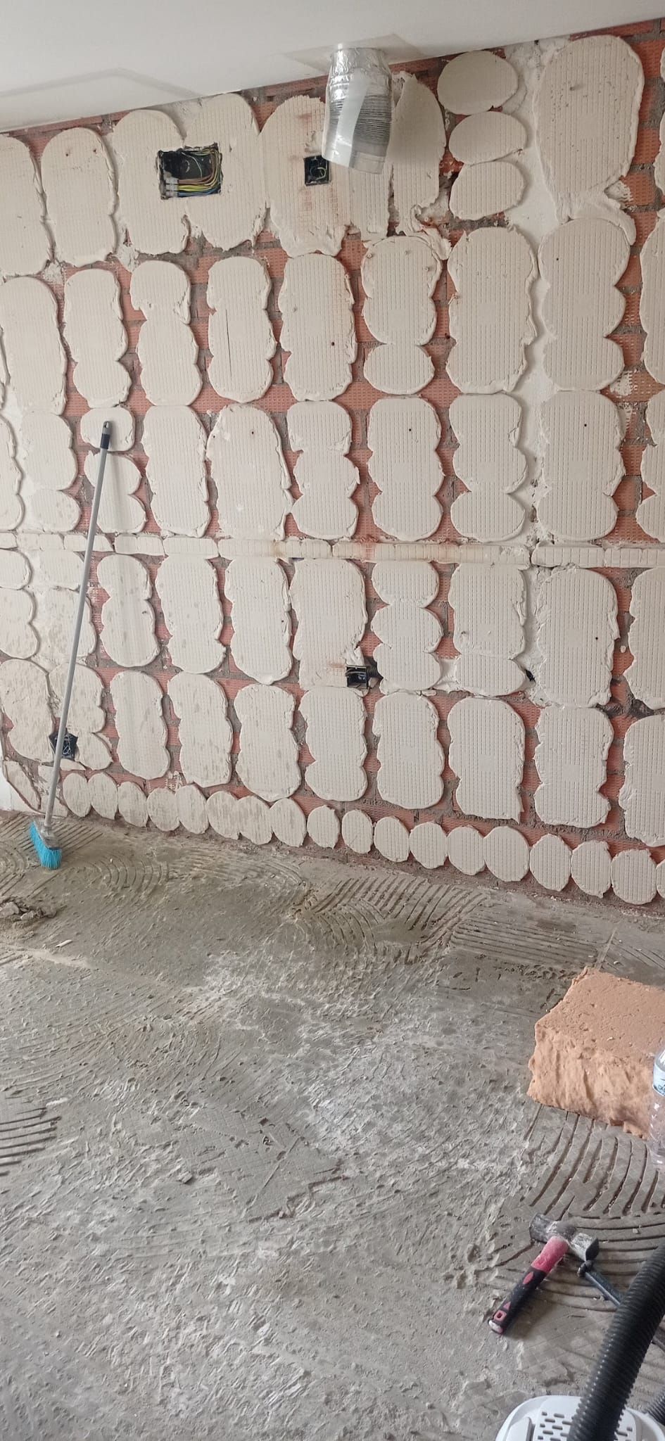 La cocina durante la obra, con las paredes picadas hasta el ladrillo y las instalaciones nuevas preparadas