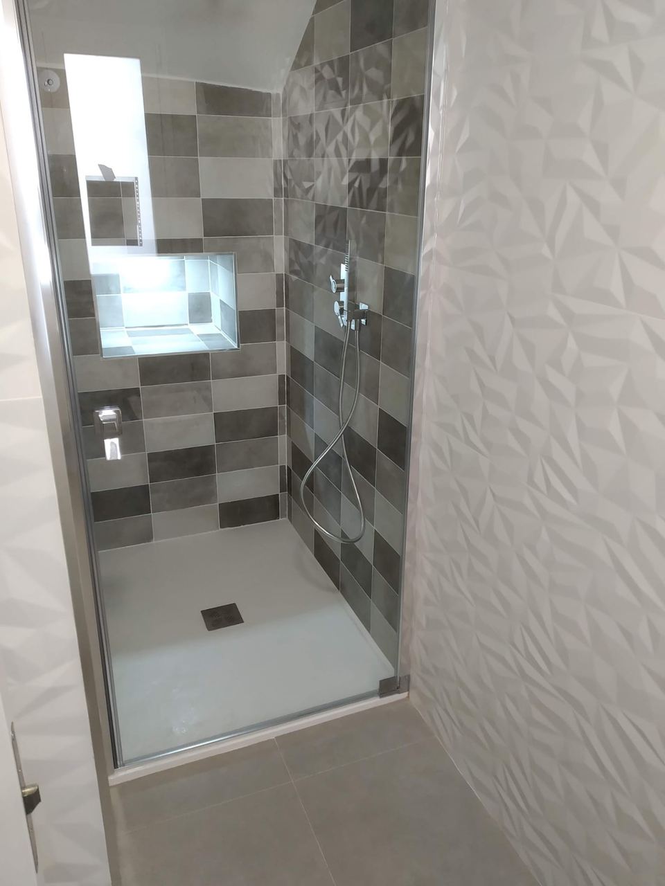 Ducha de obra con azulejo gris y plato blanco