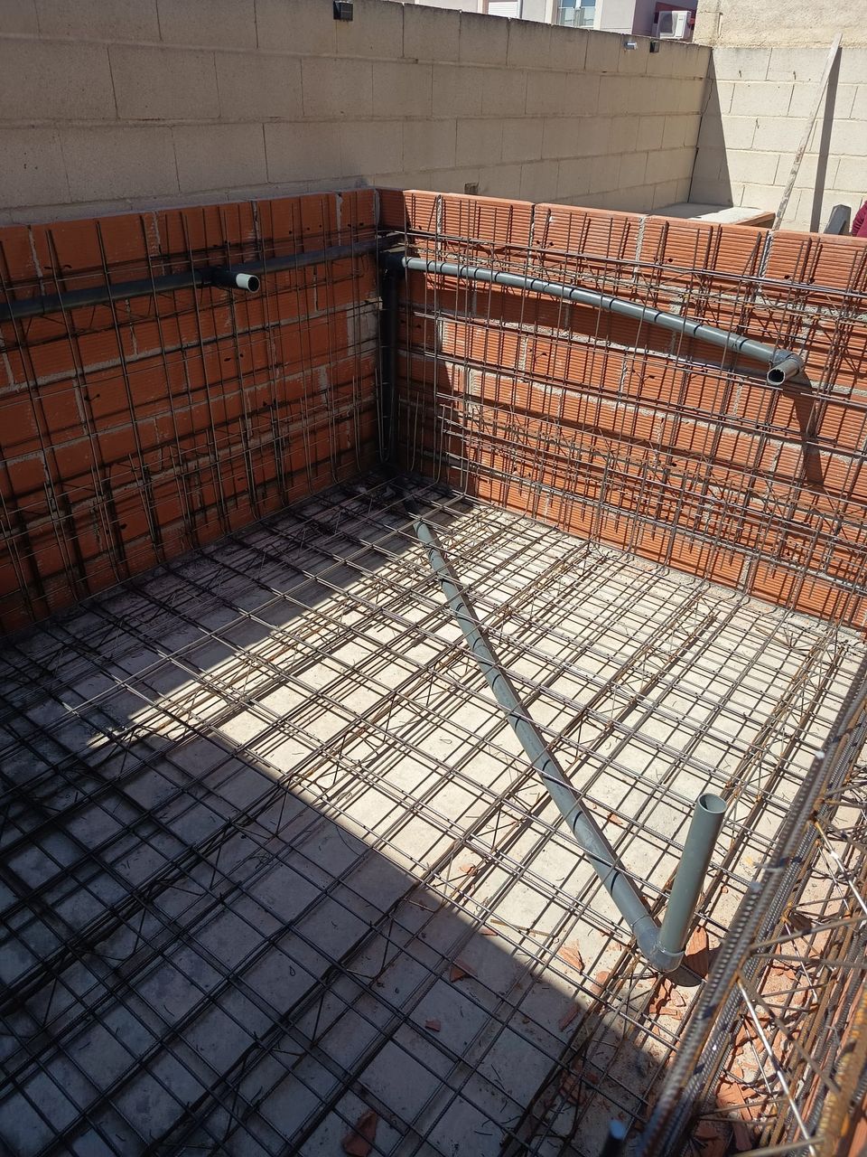 Armado de hierro y tuberías de la piscina antes de hormigonar