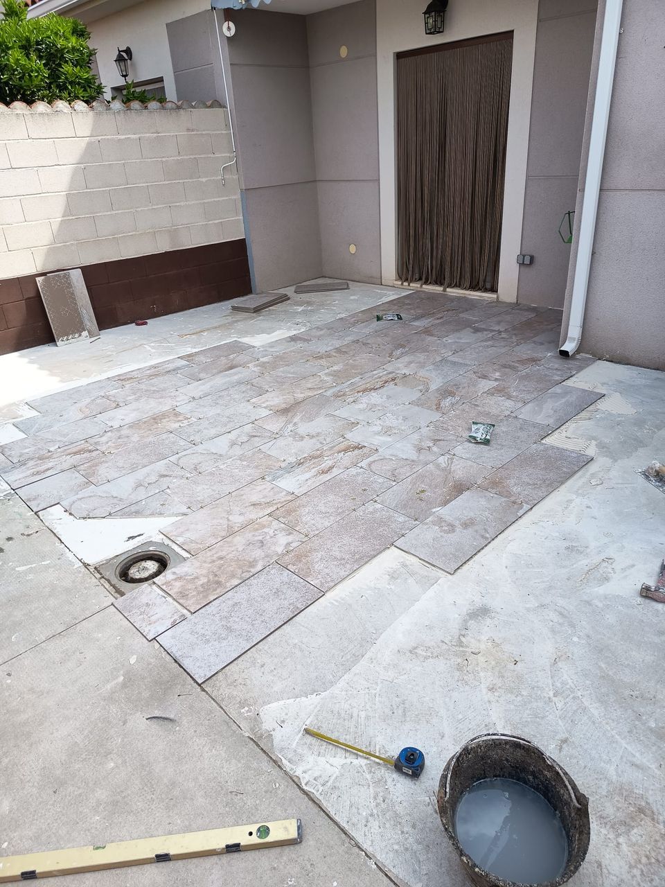 Patio con el nuevo solado porcelánico efecto piedra junto a la piscina