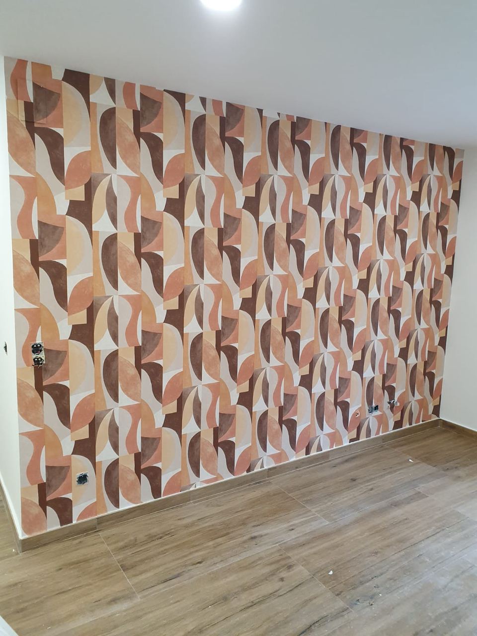 Dormitorio con papel pintado geométrico en tonos tierra