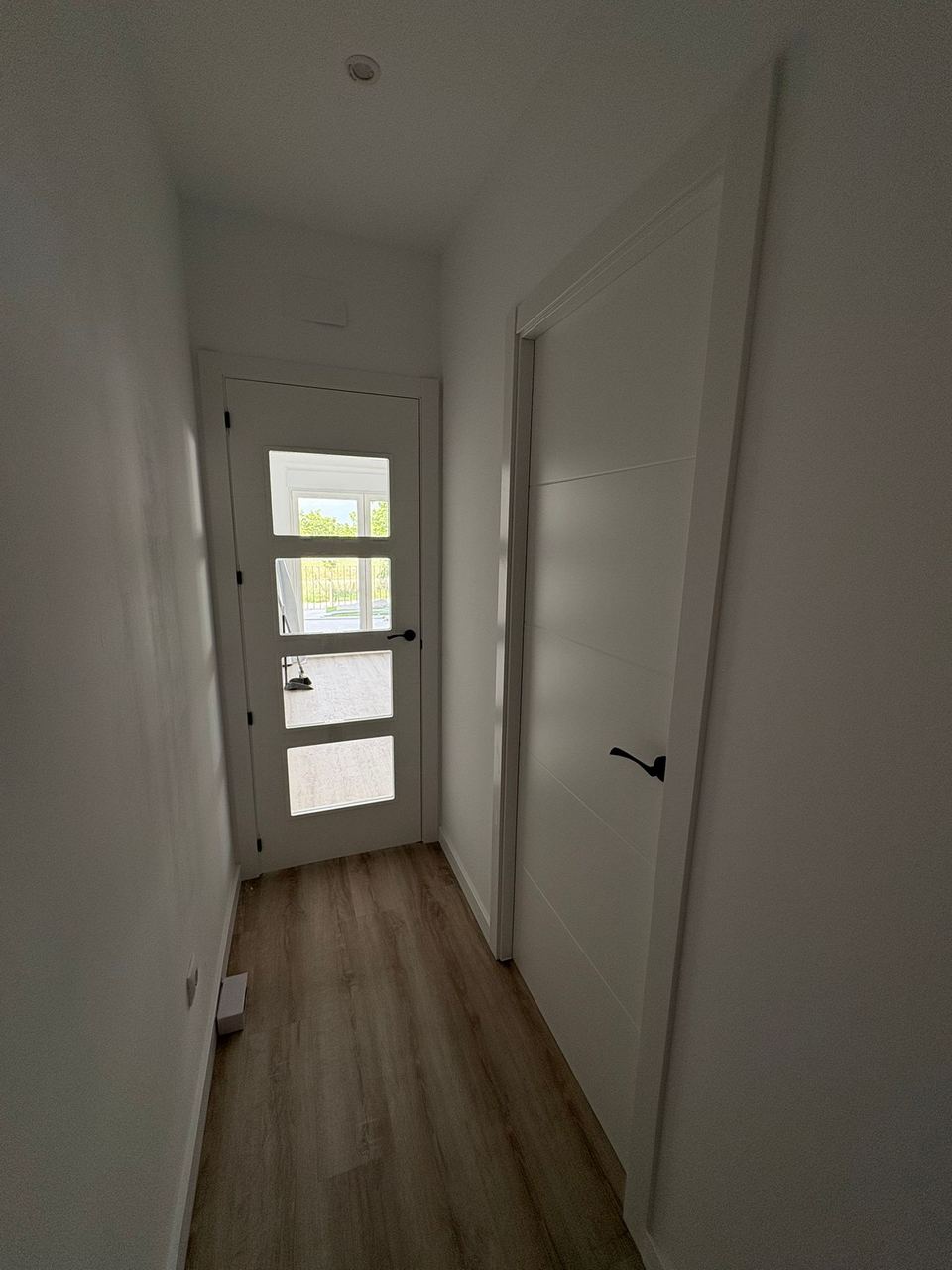Pasillo reformado en blanco con tarima