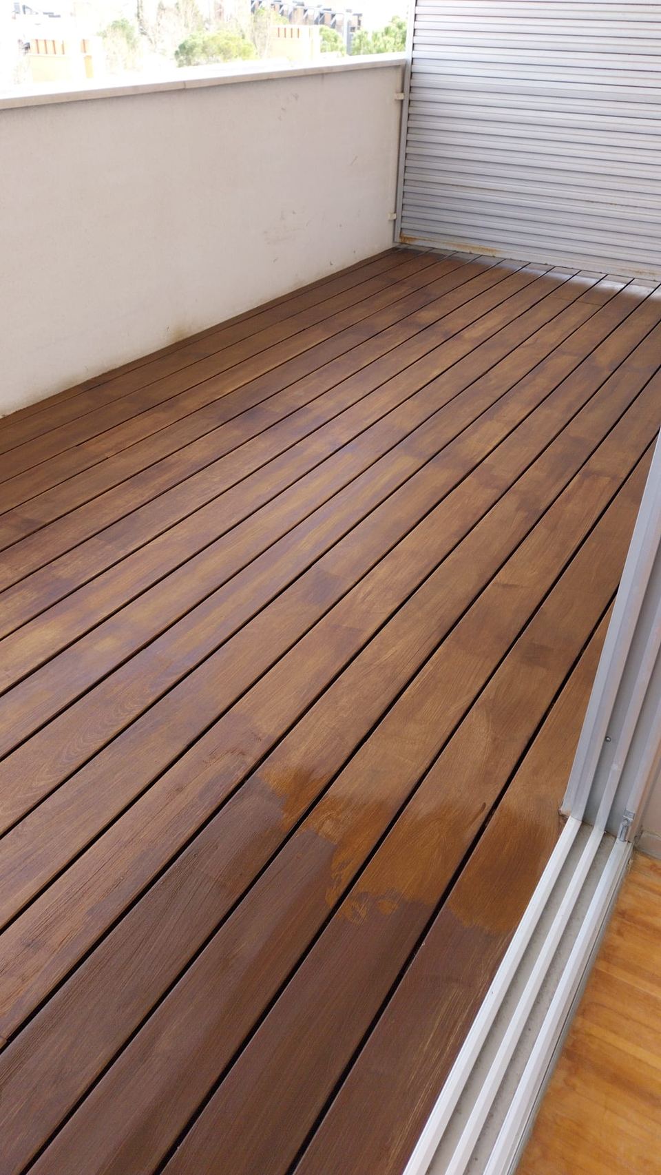 Terraza con tarima de madera y cerramiento acristalado